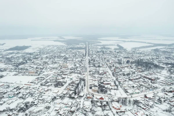 View from a height of a small village in winter. Snowy village, snow-covered houses and roads. February weather in Ukraine