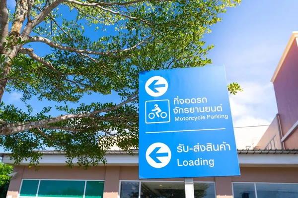 Sign turn left to motorcycle parking and drop off point  in Thai