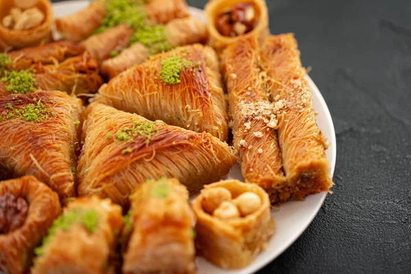 Köstliches Baklava-Dessert in orientalischer Umgebung auf schwarzem Hintergrund — Stockfoto