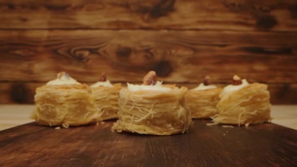 Рука берет восточные сладости на деревянном фоне, крупным планом — стоковое видео