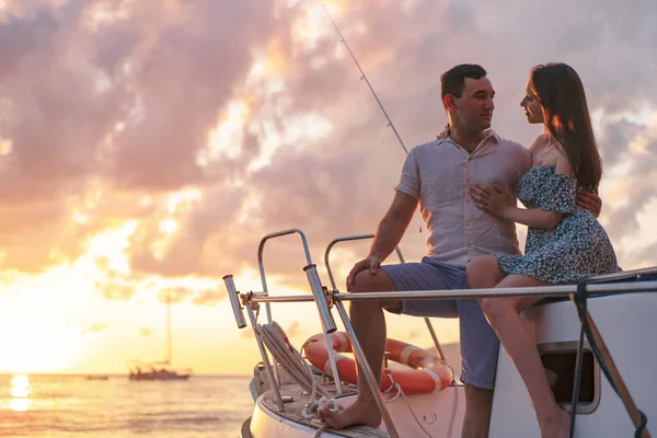 Güzel bir çift yattan gün batımını seyrediyor.