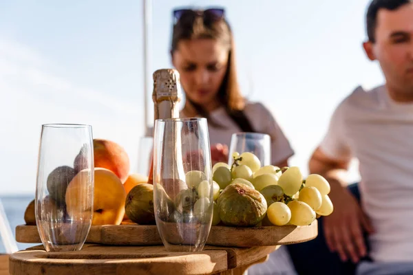 Bandeja de frutas e garrafa de champanhe para encontro romântico em um iate — Fotografia de Stock