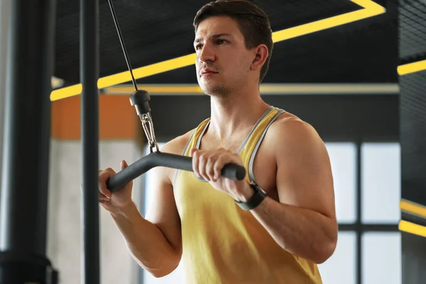 Mladý kulturista dělá těžké cvičení pro biceps v tělocvičně — Stock fotografie