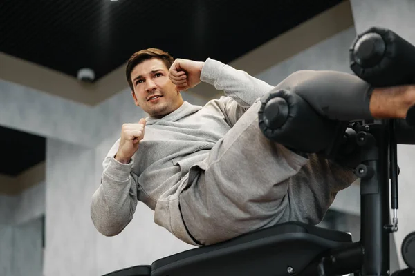 Jeune athlète faisant des exercices abdominaux séance d'entraînement dans la salle de gym moderne — Photo