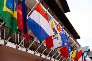 Birçok farklı eyaletin bayrakları bina cephesinde dalgalanıyor.