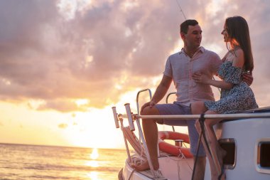 Güzel bir çift yattan gün batımını seyrediyor.