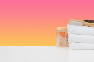 Banyo havluları ve spa tuzu beyaz masada.