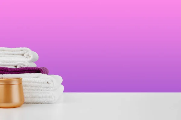 Pilha de toalhas, garrafas com shampoo na mesa branca — Fotografia de Stock