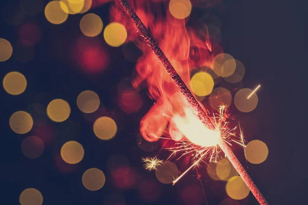 Red bengal sparkle lights close up on dark background — Stock Photo, Image