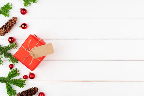 Prezent świąteczny z gałązkami świerku na drewnianym tle — Zdjęcie stockowe