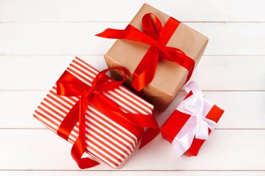 Beyaz masada kurdeleli hediye kutuları.