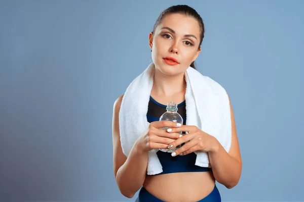 Fit mulher desportiva segurando garrafa de água mineral em sua mão — Fotografia de Stock