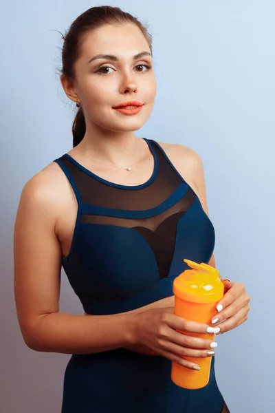 Passform sportig kvinna som håller mineralvatten flaska i handen — Stockfoto