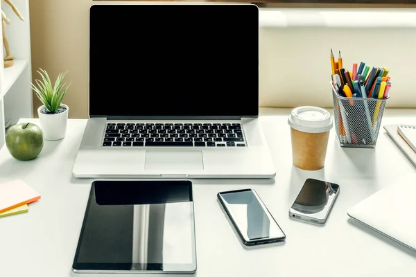 Ноутбук в светлой комнате на рабочем столе с офисными принадлежностями — стоковое фото
