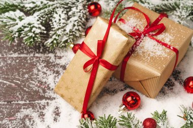 Noel hediyesi, karla kaplanmış ahşap masa.