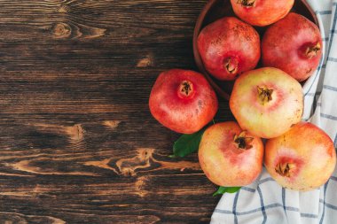 Ahşap sırtta olgun nar yığını.