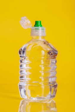 Parlak sarı arka plan üzerinde maden suyu Plastik şişe