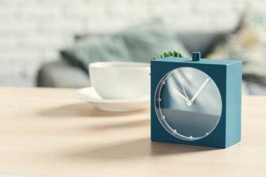 Ahşap masa üzerinde eski moda çalar saat ve ev tesisi