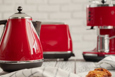 Mutfak rafında kırmızı çatal bıçak ve bulaşık takımı var.