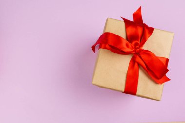 Pembe arka planı olan süslü bir hediyenin üst görünümü