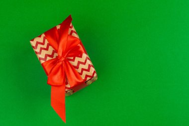 Yeşil arka planda dekore edilmiş hediye kutusu, düz üst görünüm