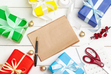 Yılbaşı tebrik kartları yazıyorum. Süslü ahşap masadaki kalemle birlikte defteri aç