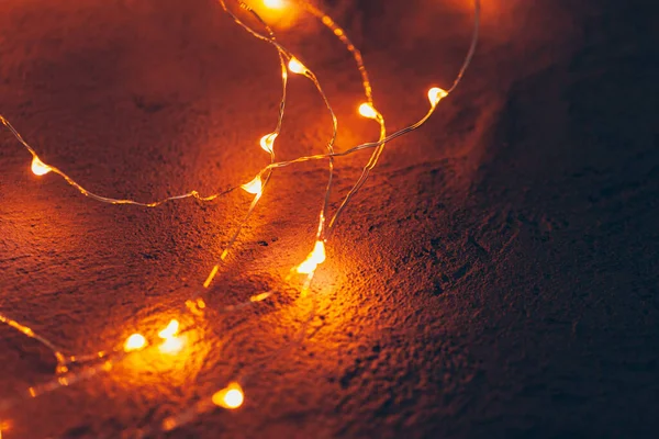 Beleuchtete Girlanden in Nahaufnahme auf dunklem Hintergrund — Stockfoto