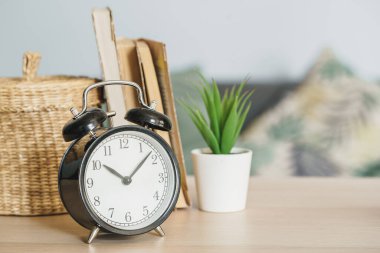 Çalar saat ve ofis kırtasiye nesneleri ahşap masada yakın