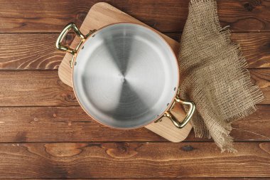 Ahşap tahtada temiz bakır mutfak malzemeleri.