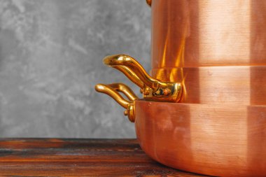 Ahşap masada bakır tencere yığını. Yakın çekim.