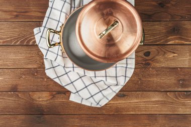 Ahşap tahtada temiz bakır mutfak malzemeleri.