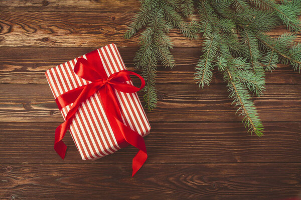Рождественские подарки и ветки сосны на деревянном столе, вид сверху