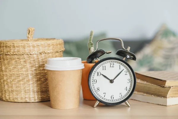 Relógio de alarme vintage clássico e xícara de café no fundo de madeira — Fotografia de Stock
