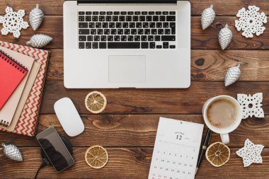 Ofis malzemeleri ve noel süslemeleri ile birlikte bilgisayarlı ahşap bir masaüstü manzarası