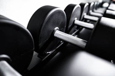 Spor salonunun rafındaki yeni halterleri kapatın.