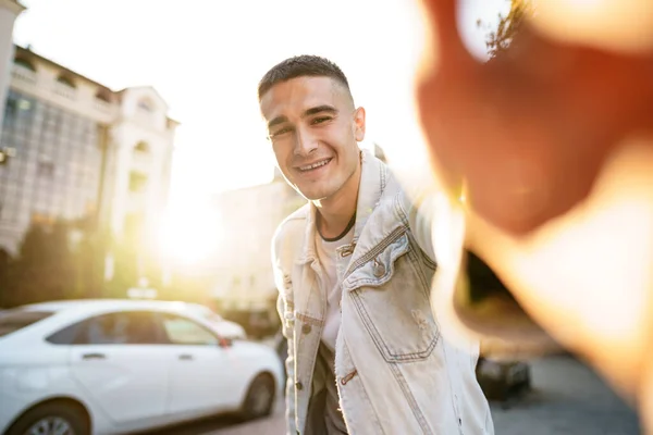Portrait of young man taking a selfie while out on the city street, close up — Stock Photo, Image