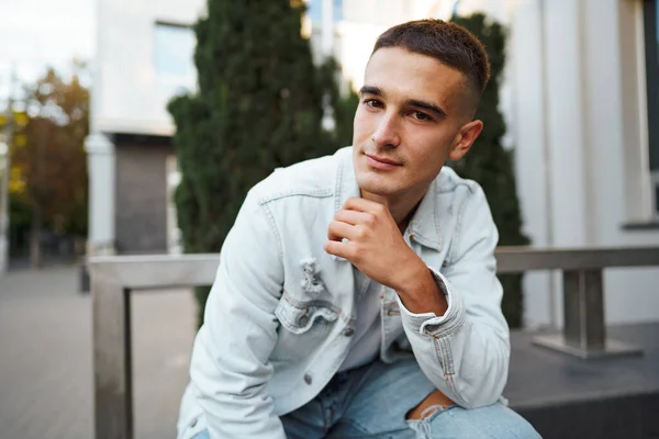 Young casual man sitting on stairs alone on street — Stock Photo, Image