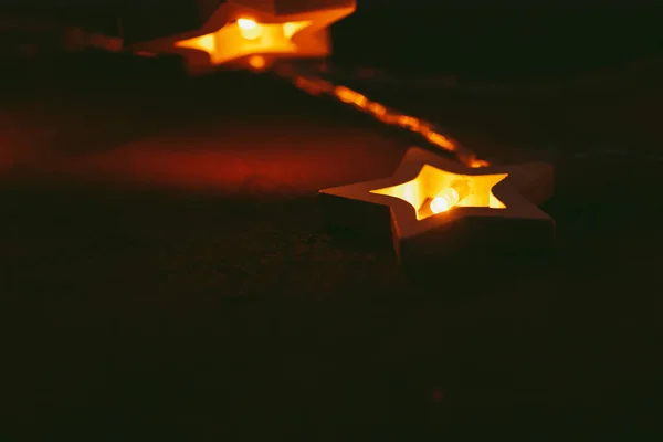Hermosa luz bokeh de guirnalda en forma de estrella en la oscuridad —  Fotos de Stock