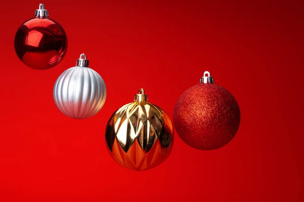 Kırmızı arka plan üzerinde havada noel bauble levitating. Noel kartı — Stok fotoğraf