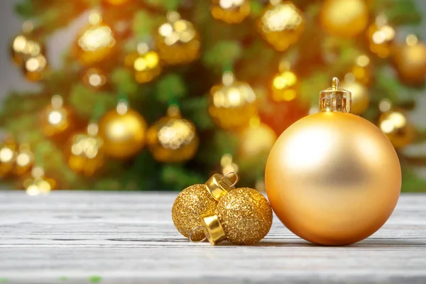 Christmas baubles on wooden table against decorated christmas tree blurred background Royalty Free Stock Images