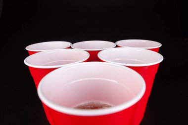 Bira oyunu için kırmızı plastik bardaklar ve top.