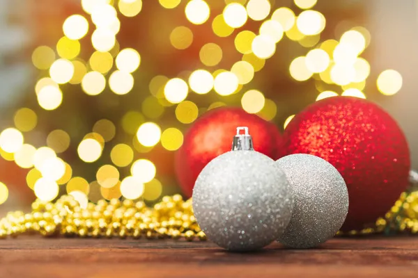 Kerstballen op een houten tafel tegen wazig glimmende bokeh achtergrond — Stockfoto