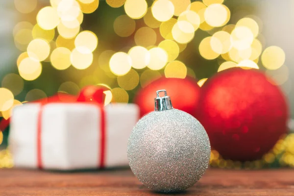 Kerstballen op een houten tafel tegen wazig glimmende bokeh achtergrond — Stockfoto