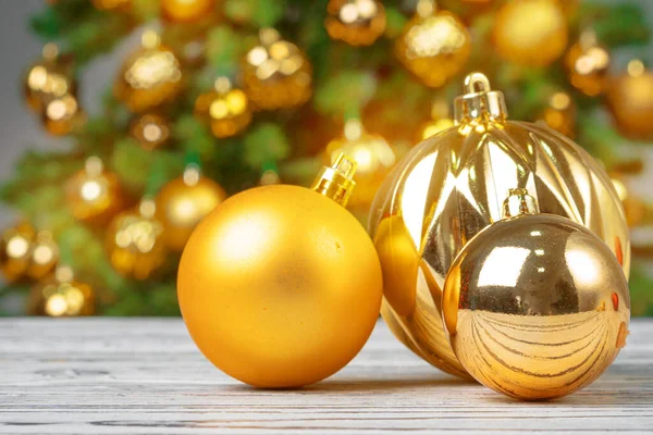 Bola de Navidad sobre mesa de madera contra fondo borroso árbol de navidad decorado — Foto de Stock