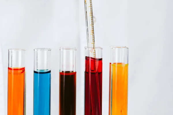 Kimyager eller sıvı ile test tüpleri tutarak ve deneyler yapıyor — Stok fotoğraf