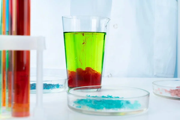 Маніпуляції з лабораторними скляними хімічними контейнерами на столі — стокове фото