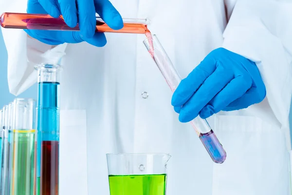 Manipulationer med laboratorieglas kemiska behållare på bordet — Stockfoto