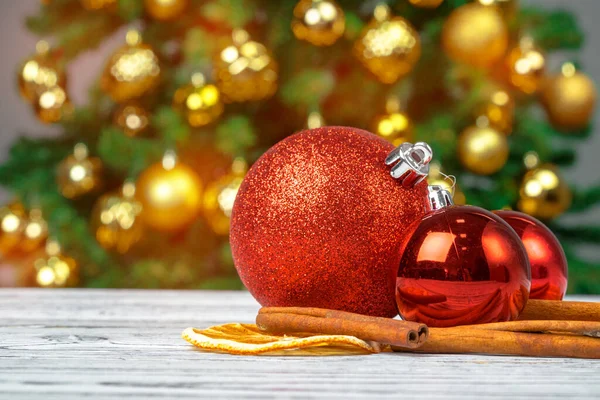 Boules de Noël sur table en bois sur fond flou arbre de Noël décoré — Photo
