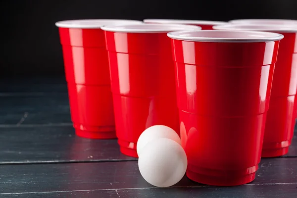 Mesa de madera con copas rojas y bola para pong de cerveza — Foto de Stock