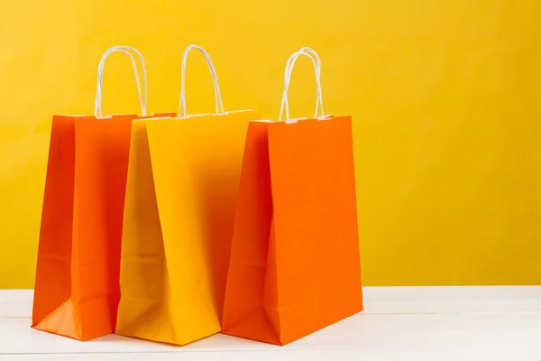 Arreglo de bolsas de compras sobre fondo amarillo brillante —  Fotos de Stock